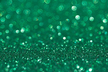 Shining green glitter background. Abstract texture with bokeh effect.