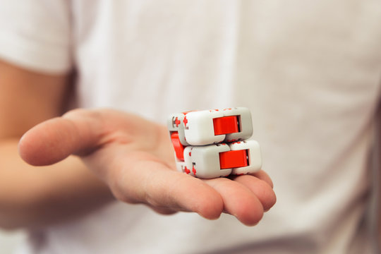A teenager boy turns nanocube. Antistress for hands. Logical and creative cube.