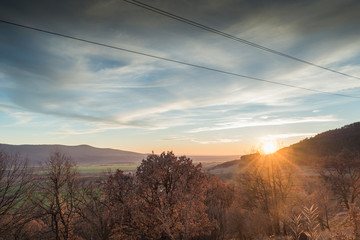 A scenic sunset over a wooded area.