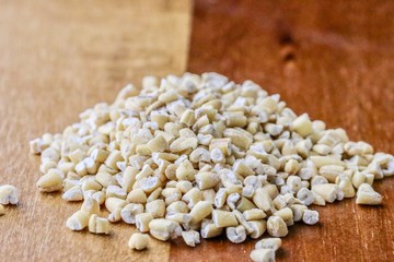 Steele cut oats on wooden board macro