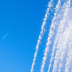 Jets and splashes of water fountain against the blue skyCondensa