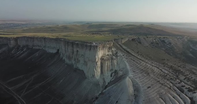 Aerial view drone shadow flying back over rocks, birds fly into camera, cape White Canyon, bright sun at sunset, cliffed Tropical 4K, cliffed coast line Crimea Rocks line.