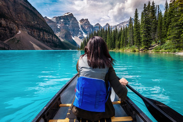 Tourist canoeing on Moraine Lake in Banff National Park, Canadian Rockies, Alberta, Canada. - obrazy, fototapety, plakaty