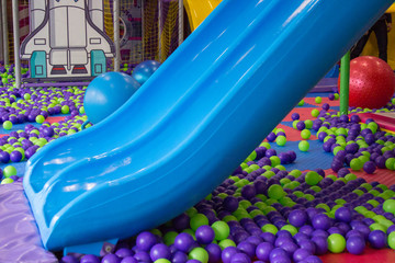 children's slide in the room,Children's playground with blue plastic slider and colorful plastic balls in pool