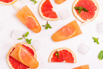 Fototapeta na wymiar Homemade grapefruit popsicle with ripe grapefruit slices and fresh mint
