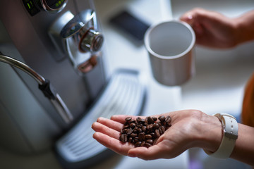 Young lady making fresh strong coffee for breakfast