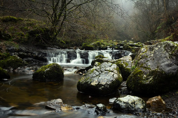 Beautiful natural river in the Scottish Highlands on a cold and misty winter morning. 