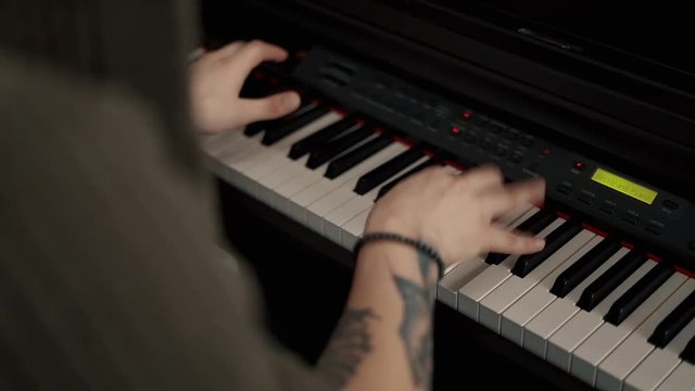 Musician playing synthesizer, slow motion.