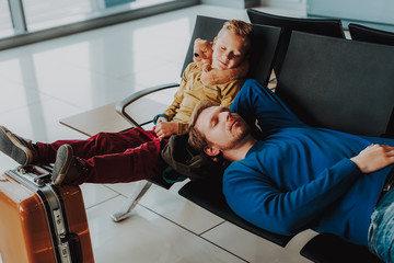 Father and son are sleeping in airport lounge