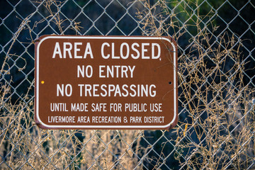 "Area closed, No entry, No trespassing" sign posted on a fence by Livermore area recreation and park district, Livermore, San Francisco bay area, California