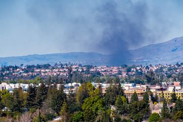 Smoke from a fire rising over residential areas in south San Jose, San Francisco bay area, California