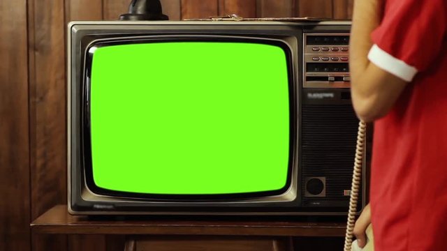 Teenage Boy Talking On Old Phone and Watching Old TV Green Screen.  You can replace green screen with the footage or picture you want with “Keying” effect in After FXs . 