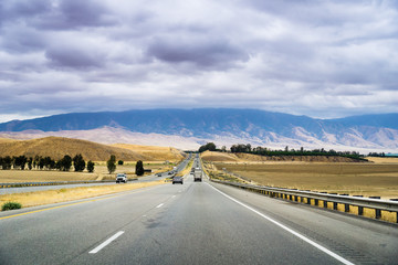 Driving through one of the rural areas of California, close to Bakersfield, on a cloudy day