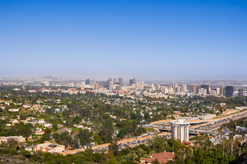 Fototapeta na wymiar Aerial view towards the skyline of Century City commercial district; downtown area skyscrapers visible in the background; highway 405 and residential area in the foreground; Los Angeles, California