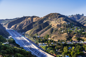 Aerial view of highway 405 with heavy traffic; the hills of Bel Air neighborhood in the background;...