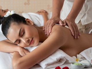 Asian woman relaxing and smile on bed mattresses In the Spa. Thai massage for health. Select focus hand of masseuse.