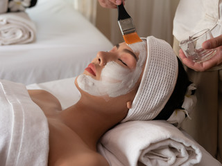 Fototapeta na wymiar Beautiful young asian woman with facial mask at beauty spa salon. Beauty Treatments