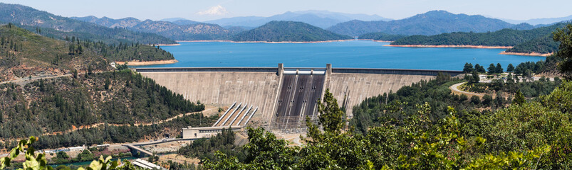 Panoramic view of Shasta Dam on a sunny day, Shasta mountain visible in the background; Northern California - obrazy, fototapety, plakaty