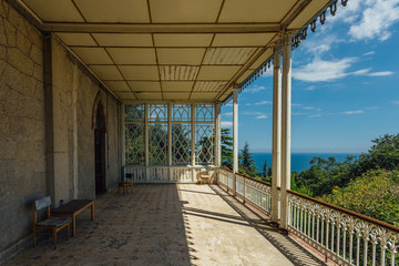Fototapeta premium Abandoned mansion. Large decorated balcony with columns on sea coast
