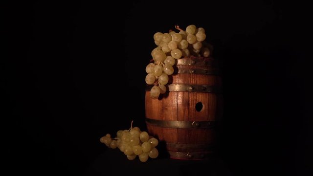 Backward rotating wine barrel with some grapes.