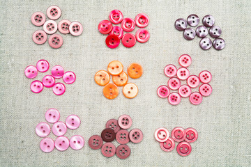 Lots of colorful sewn-on buttons of different colors on a linen lightweight natural fabrics  
