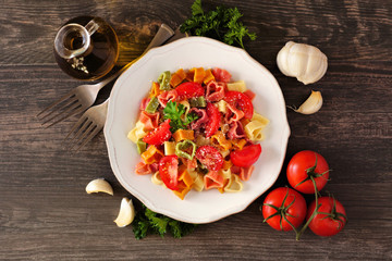 Heart shaped pasta for Valentines Day over a dark wood background. Top view table scene.