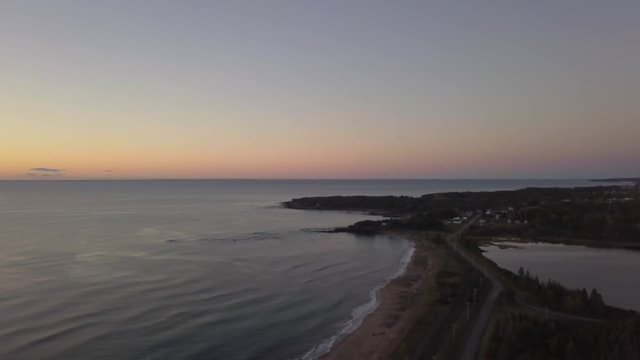 Aerial view of a Beautiful Sandy Beach on the Atlantic Ocean Coast during a vibrant sunrise. Taken near in Pabos Mills, Quebec, Canada.