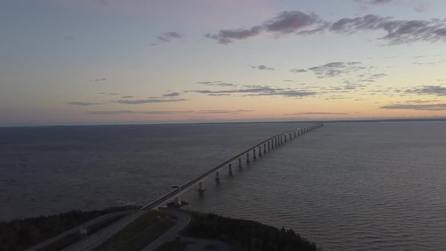 Aerial view of Confederation Bridge to Prince Edward Island during a vibrant sunny sunrise. Taken in Cape Jourimain National Wildlife Area, New Brunswick, Canada.