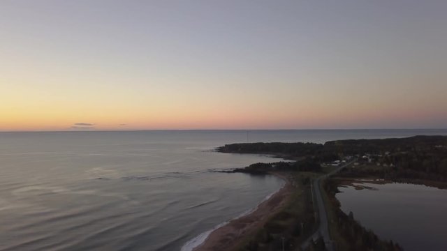 Aerial view of a Beautiful Sandy Beach on the Atlantic Ocean Coast during a vibrant sunrise. Taken near in Pabos Mills, Quebec, Canada.