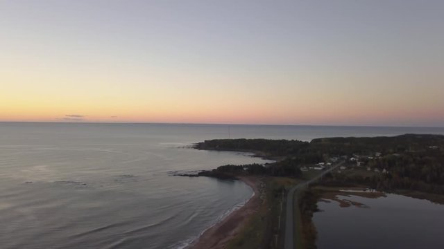 Aerial view of a Beautiful Sandy Beach on the Atlantic Ocean Coast during a vibrant sunrise. Taken near in Pabos Mills, Quebec, Canada.