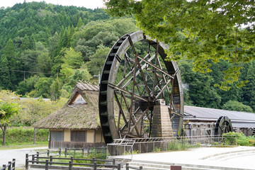 Water mill is at the side of the hut in Japan.