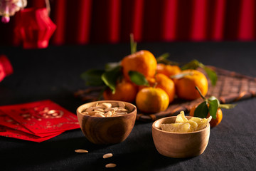 Lunar new year food and drink still life on black background. Translation of text appear in image: Prosperity.