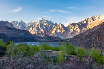 Tupopdan mountain also known as Passu Cones or Passu Cathedral, big rocks all over the place and blue crystal of Hunza river at sunset time ,Northern of Pakistan