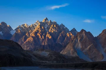 Papier Peint photo Gasherbrum Montagne Tupopdan également connue sous le nom de Passu Cones ou Cathédrale de Passu, gros rochers partout et cristal bleu de la rivière Hunza au coucher du soleil, nord du Pakistan