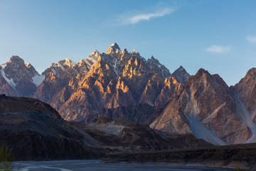 Tupopdan mountain also known as Passu Cones or Passu Cathedral, big rocks all over the place and blue crystal of Hunza river at sunset time ,Northern of Pakistan