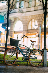 Fototapeta na wymiar Bicycle Equipped Basket Parked In European City Street In Night 