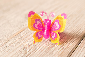 Toy butterfly on a wooden table. Children's toy