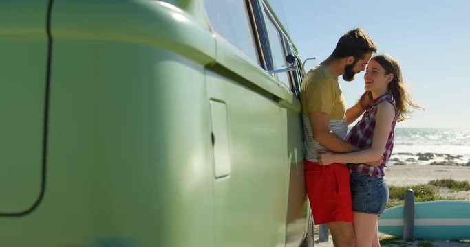 Young couple kissing near van on a sunny day 4k
