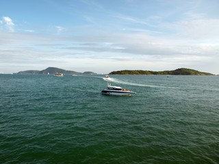 Motor boat on the sea, view to the several small islands in a horizon. Rushing speedboat in a distance. Active moving on the water of boats, cutters. Amazing blu sky with beautiful clouds. Seascape