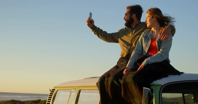 Couple taking selfie during sunset on beach 4k