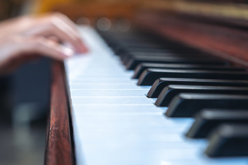 Obraz premium Closeup image of hands playing a vintage wooden grand piano