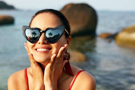 Happy Woman In Heart Shaped Sunglasses On Beach Closeup