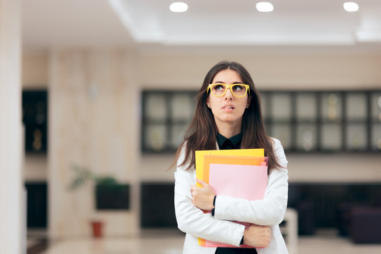 Confused Businesswoman Holding Paperwork in Office Building