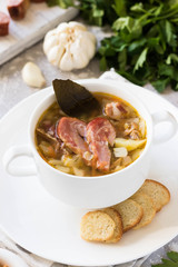 Thick pea soup with smoked meats in a white plate