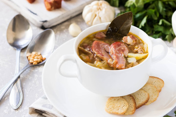 Thick pea soup with smoked meats in a white plate
