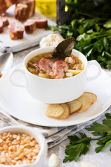 Thick pea soup with smoked meats in a white plate