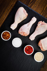 Raw chicken drumsticks on wooden background