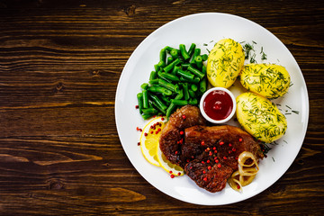 Grilled pork chop, boiled potatoes and green beans