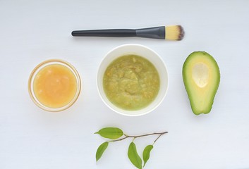 Homemade face mask with avocado and honey, natural cosmetics, top view.