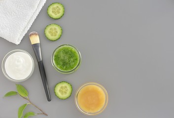 Fresh cucumber, honey and yogurt homemade face mask, flat lay on gray background with copy space.